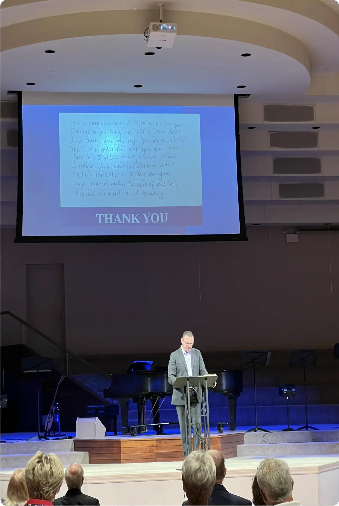 Church-led police appreciation event with speaker reading thank-you message for first responders