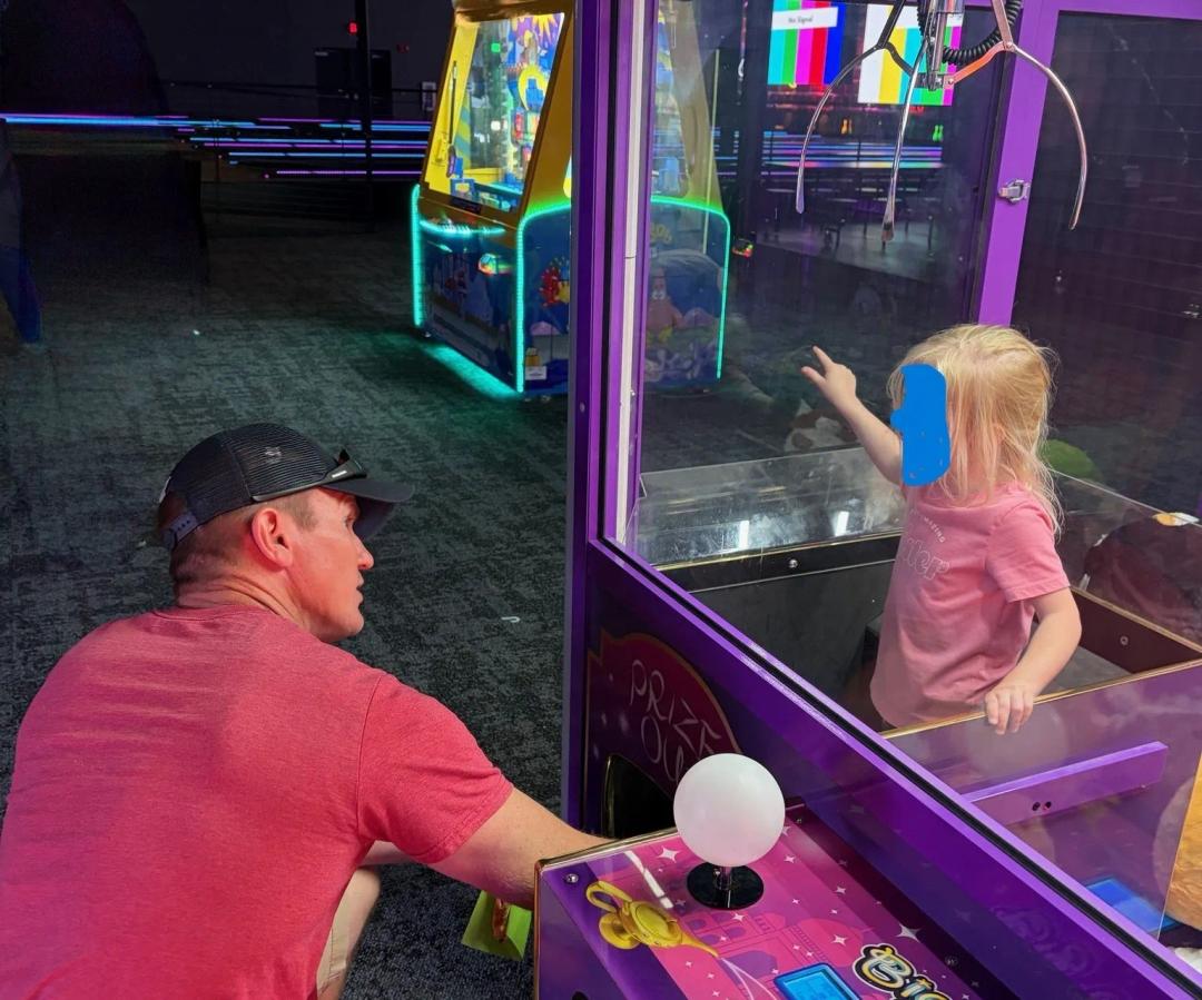 An off duty Missouri police officer assists a small child stuck in the prize area of an arcade machine.