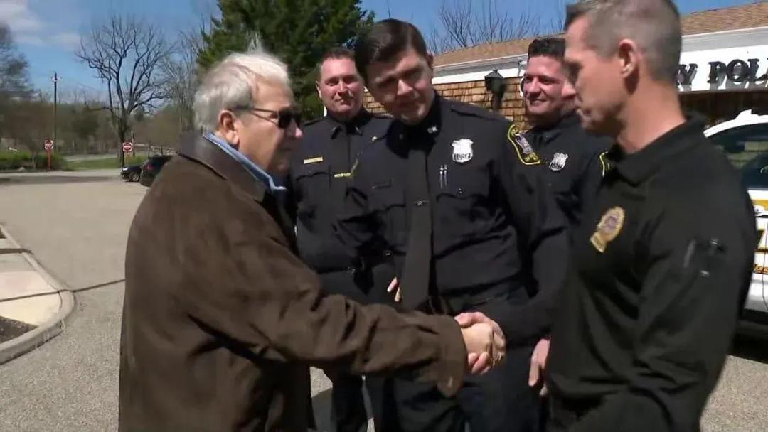 Phillip Amico shaking hands with Old Westbury Police officers in Nassau County New York after his life-saving rescue