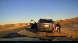 Image from the Kansas Highway Patrol showing the moment of a roadside rescue involving a trooper and a young kidnapping victim.