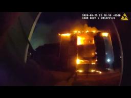 Irving Police body-worn camera view of an apartment building engulfed in flames at night