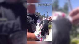 Phoenix Police officer gently holds a newborn baby after performing an infant rescue during a welfare check