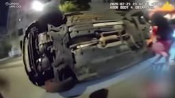 LAPD bodycam footage showing an officer and bystanders working together to lift an overturned car after a crash in Los Angeles.