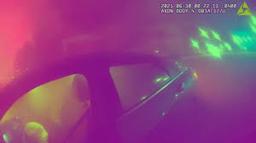 A smoky, chaotic view from a Sarasota Police body-worn camera as officers perform a car fire rescue