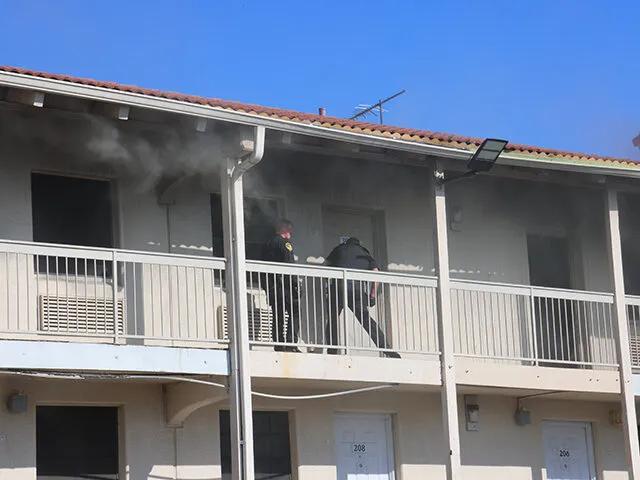 White Settlement Police Department officers are seen moving through thick smoke on a motel balcony while performing an emergency fire rescue