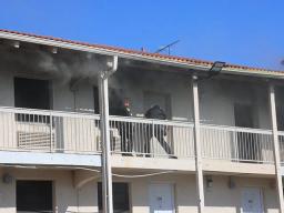 White Settlement Police Department officers are seen moving through thick smoke on a motel balcony while performing an emergency fire rescue