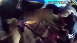 Bodycam footage of Miami Beach police officers working together to lift a vehicle during a rescue operation.