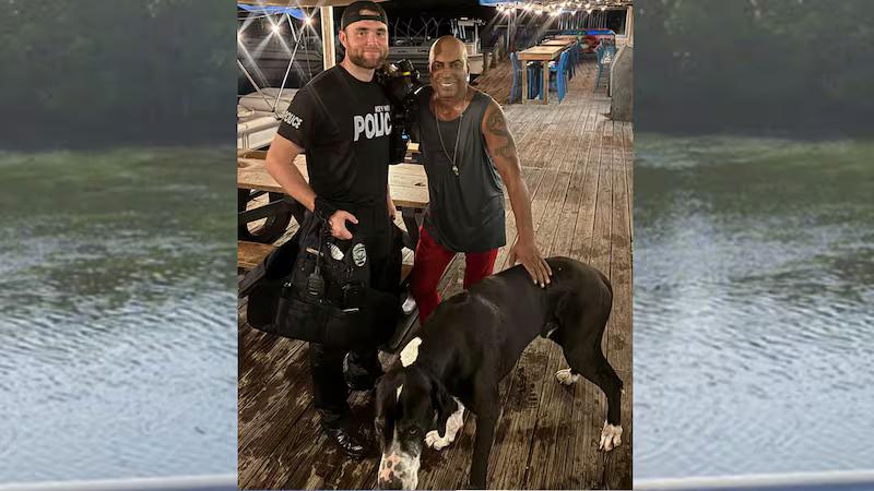 Key West police officer standing with a man and his rescued Great Dane on a waterfront dock at night