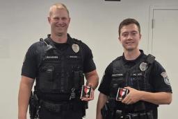Officer Kevin Richards and Officer Tyler Sutton stand in uniform displaying their department commendations.