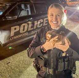 Small brown puppy resting in the hands of a Lynnwood Police officer after being rescued.