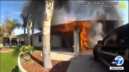 Bodycam footage shows the garage of a Westminster home fully engulfed in flames as police arrive to perform a house fire rescue.