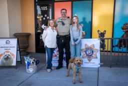 A goldendoodle named Jet Blue standing with his new family and an LVMPD officer in Las Vegas.