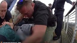 Sevierville Police officers pulling a man in crisis over a bridge railing to safety.