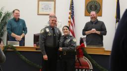 A fellow officer congratulates Officer Whitney Buerger after she received the Excellence in Service Award for a successful defibrillation.
