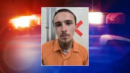 Suspect mugshot of Branch Stamper shown with facial tattoos and an orange detention shirt set against emergency police vehicle lights.